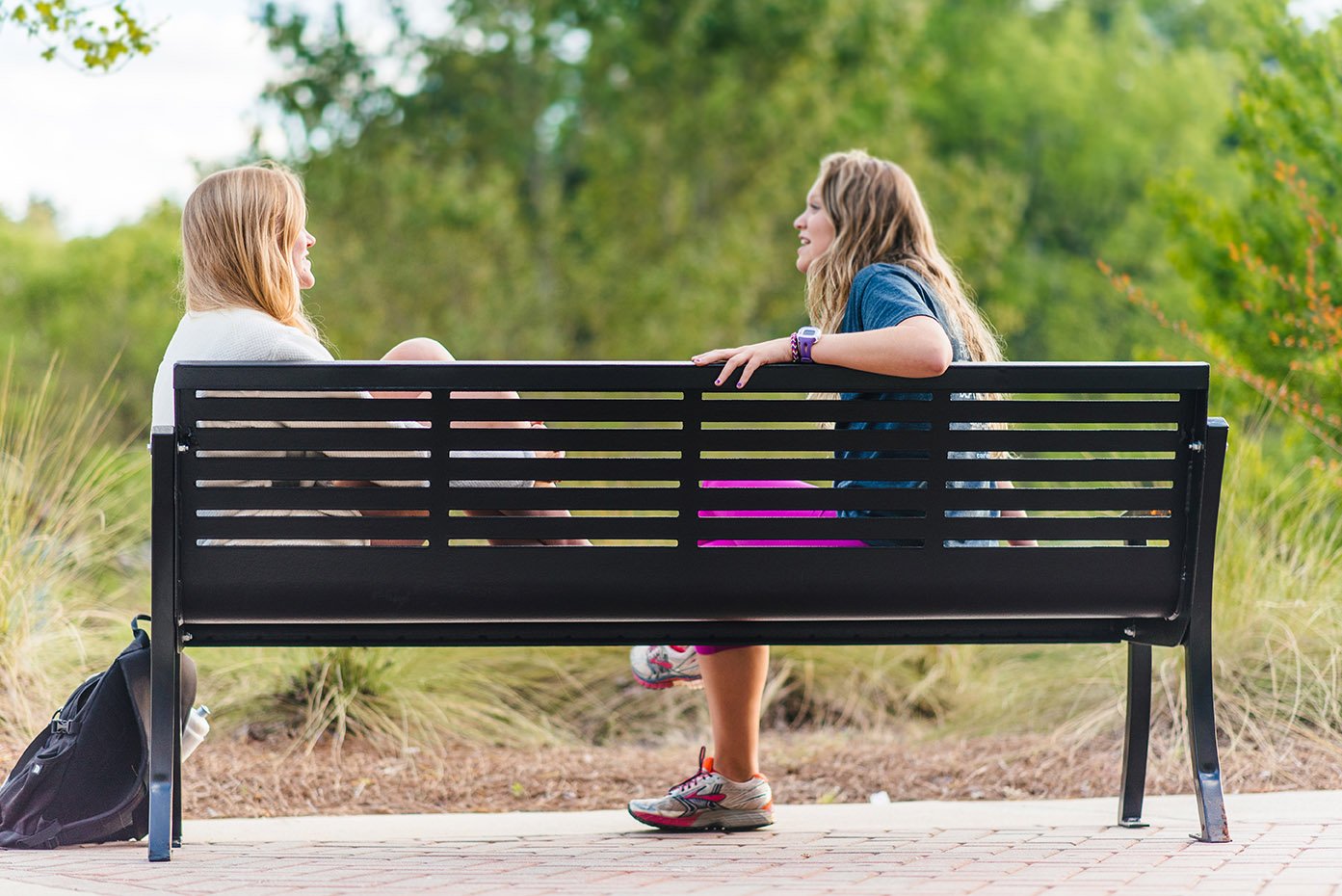 2 women sit at a Horizontal Strap Bench